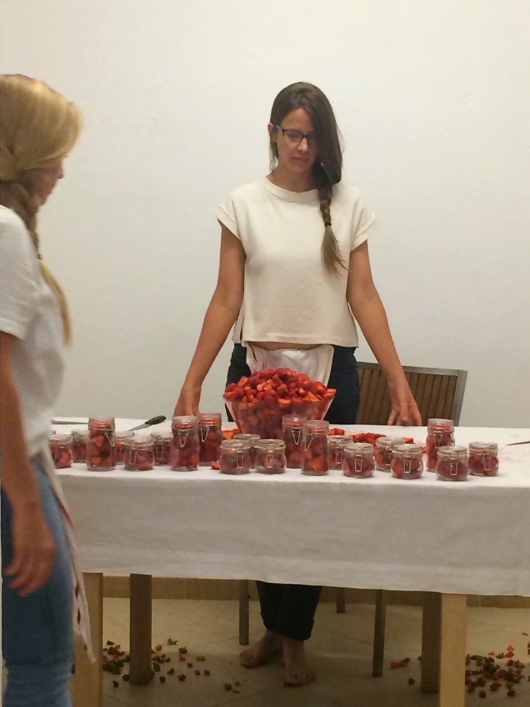 After all the strawberries are prepared, they are placed in glass jars.